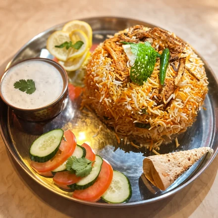 Chicken biryani with raita and sliced vegetables at Lutf Indo-Pak Cuisine