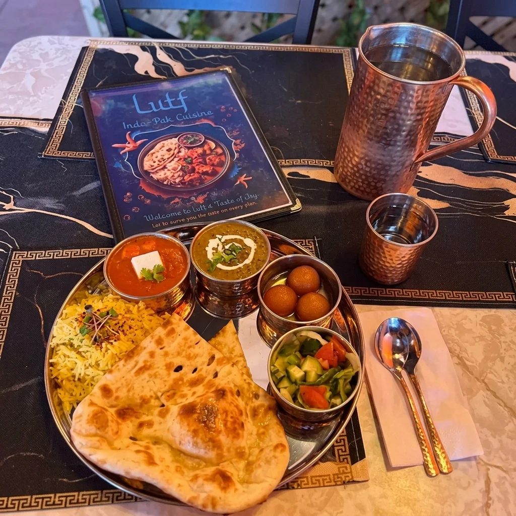 Thali with naan, rice, paneer curry, dal and gulab jamun beside the Lutf menu at Lutf Indo-Pak Cuisine